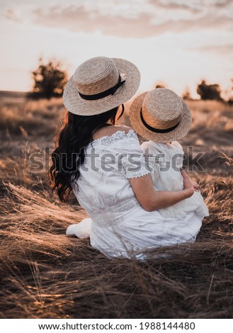 Happy smile family mother mom boater hat child daughter having fun outdoors nature sunset summer. close up Portrait love couple baby girl together play rest child in arms parents kiss hug sitting back