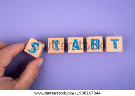 Start. Wooden cubes with text on a purple background.