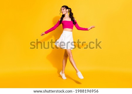 Full size photo of young attractive woman happy positive smile go walk step look empty space isolated over yellow color background