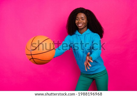 Photo of shiny funny dark skin lady wear blue hoodie catching basket ball isolated pink color background