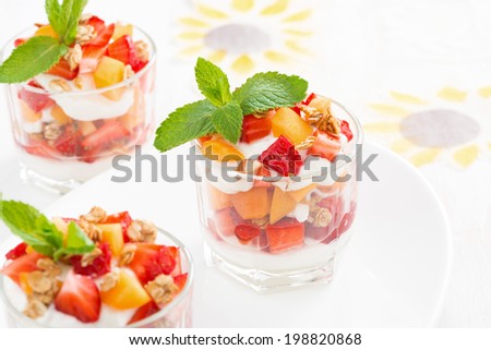 dessert with strawberries, apricots, whipped cream and mint in glasses, close-up