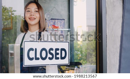 Happy Asian beautiful young woman staff turning round sign to close on door, Female owner of coffee shop closed the service on window, small business