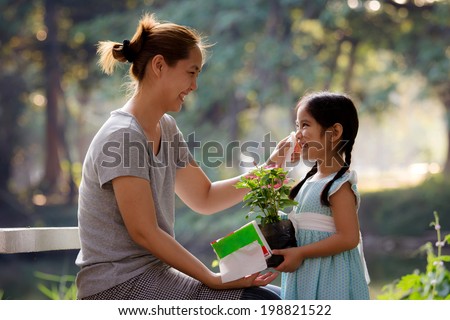 Happy Asian mother cleaning her daughter's face, Plant together Royalty-Free Stock Photo #198821522