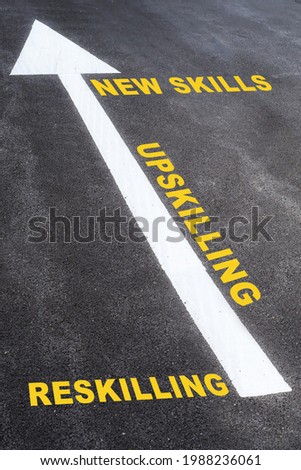 Newskills, upskilling and reskilling with white arrow sign marking on road surface for giving direction. Growth mindset concept and self improvement idea Royalty-Free Stock Photo #1988236061