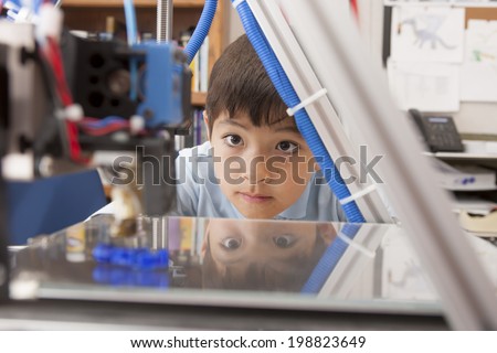 Boy watches machine intently. Royalty-Free Stock Photo #198823649