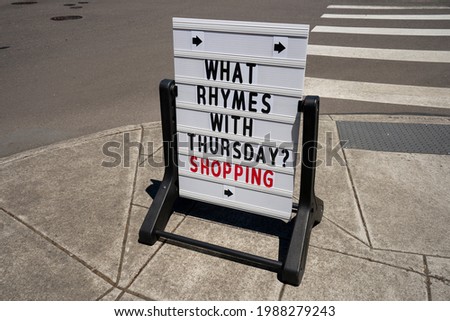 Retail store promotion signage on the sidewalk. What rhymes with Thursday meme. Consumerism concept.