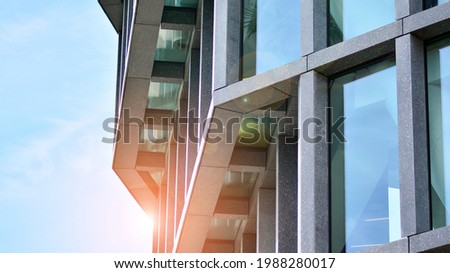 Abstract image of looking up at modern glass and concrete building. Architectural exterior detail of office building. Industrial art and detail. Sunrise.