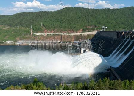 A long plume of water discharged from a hydroelectric power plant. Ensuring the operation of hydroelectric structures. Royalty-Free Stock Photo #1988323211