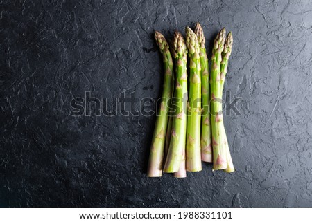 Green asparagus sprouts on black board top view flat lay. Food photography