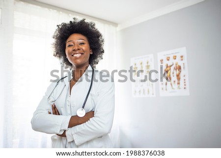 Medical Doctor Indoors Portraits. Portrait of a confident doctor working at a hospital. Waist up portrait of beautiful African-American nurse posing confidently while standing with arms crossed