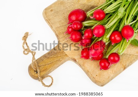 Bunch of fresh radishes on kitchen wooden cutting board. Studio Photo.
