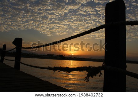 Beautiful sunset on the beach, near mountains. View from the bridge