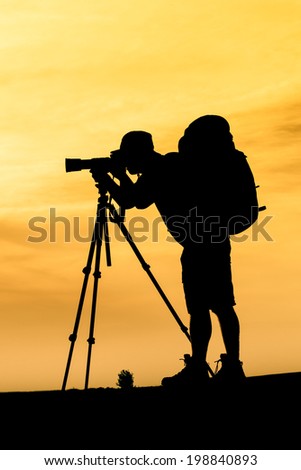 Silhouette of photographer shooting for a sunrise