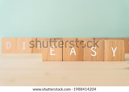 EASY; Wooden blocks with "EASY"  text of concept.