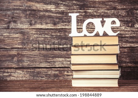 Word love and books on wooden table.