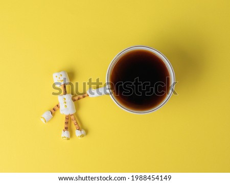 A cup of coffee in the hands of a marshmallow man on a blue background. A collage of sweets. Flat lay.