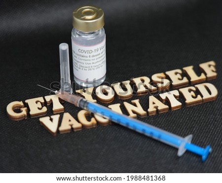 Get yourself vaccinated wooden alphabet with needle syringe and vaccine in the picture.