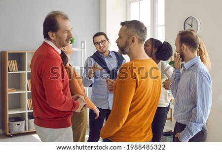 Groups of different people standing randomly and talking during informal business meeting. Diverse multiracial team having nice friendly chat with teammates. Conversation, discussion, sharing emotion Royalty-Free Stock Photo #1988485322