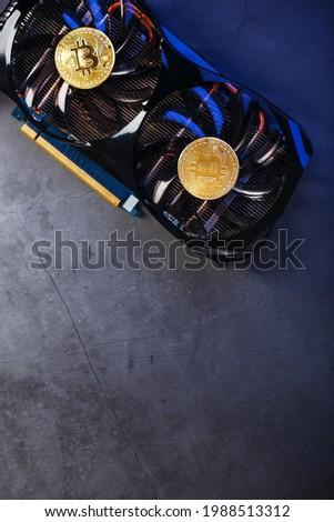 Gold Bitcoin on the video card cooler on a dark background top view. The concept of mining and mining of cryptocurrency, the device of a cryptocurrency farm.