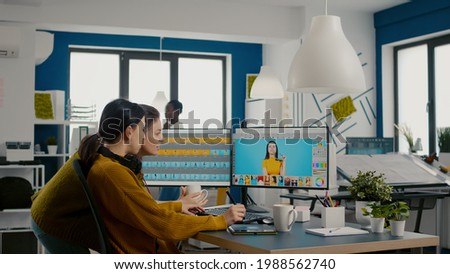 Two photographers advising for retouching client photo in creative media agency office. Graphic designers working at client assets on PC with two displays in photo editing software holding stylus pen