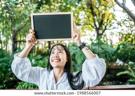 hand woman holding black board in the garden
