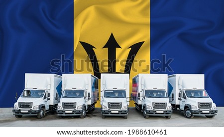 Barbados flag in the background. Five new white trucks are parked in the parking lot. Truck, transport, freight transport. Freight and logistics concept