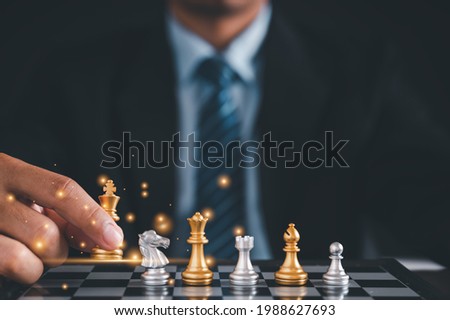 Businessman in black suite sitting player chess.meaning of planning and strategy ecision achievement goal concept of business.