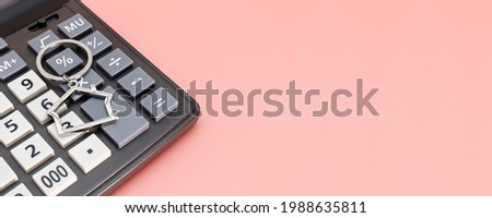 The concept of mortgage, sale and rental of housing and real estate. Calculator with keys and a keychain in the form of a house on a gentle pastel background. Banner format. Copy space