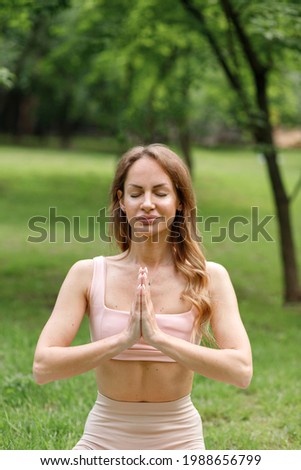 Woman meditates in city park on green yoga background
