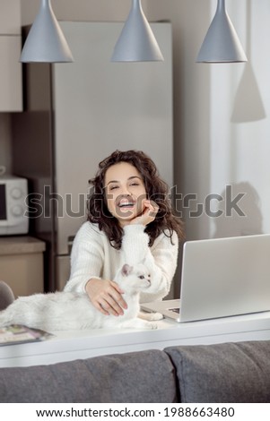 Pretty young dark-haired woman at home with her pet