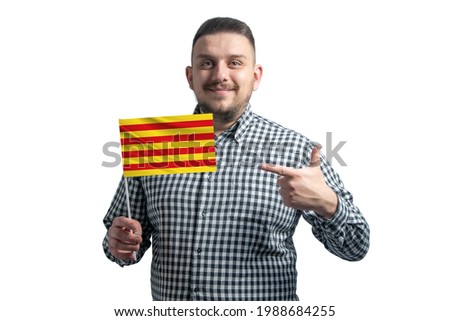 White guy holding a flag of Catalonia and points the finger of the other hand at the flag isolated on a white background.