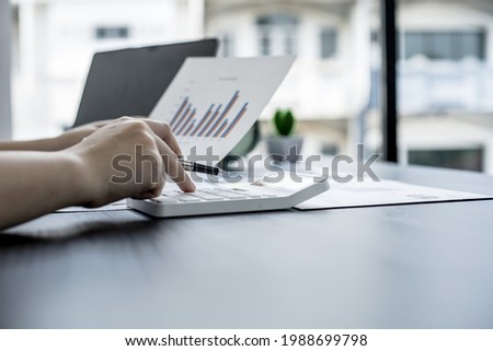 The head sales department checks the monthly sales datasheet for the salesperson to calculate the monthly commission, she looks at the document and presses the calculator. Sales management concept Royalty-Free Stock Photo #1988699798