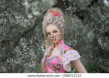 Portrait of a blond girl with an aristocratic hairstyle in a pink corset