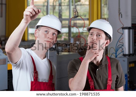 Engineer showing something at production area to his collaborator