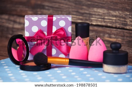 Cosmetics and gift box on woodent table.