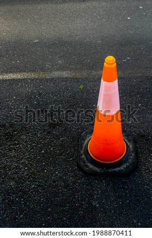 Orange safety cone with single broad white stripe
