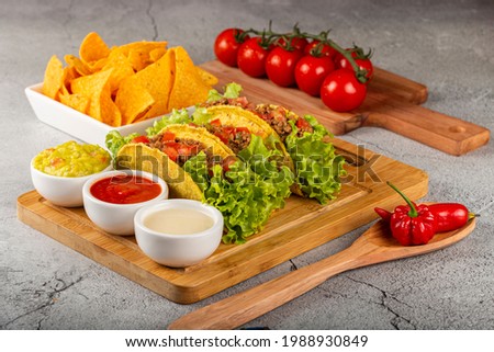 Mexican tacos with lettuce, beef and tomatoes.