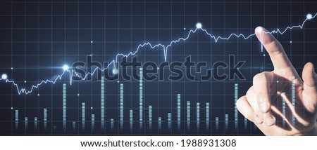 Trade and finance concept. Hand pointing at abstract glowing forex chart on dark background