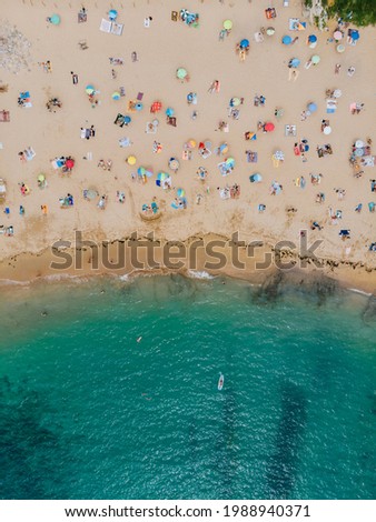 Aerial shot of beautiful beach with pastel colored umbrellas and turquoise water