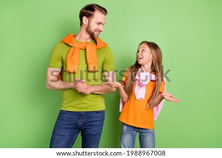 Portrait of attractive cheerful people communicating spending free time isolated over green color background