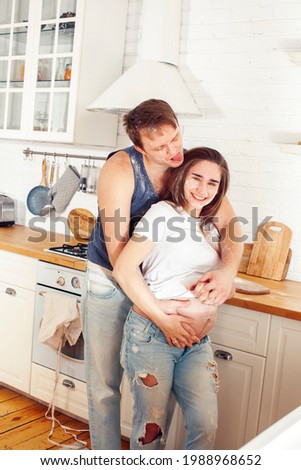young caucasian couple together having fun on kitchen, woman pregnant, lifestyle people concept
