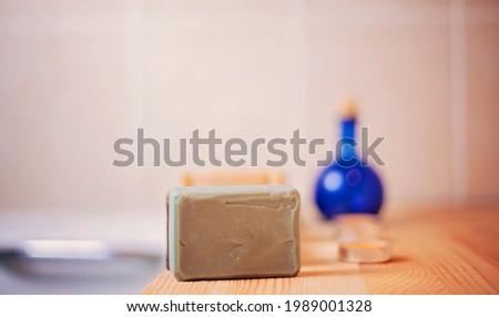 Handmade beautiful bars of organic soap displayed beside a luxurious hot bath.