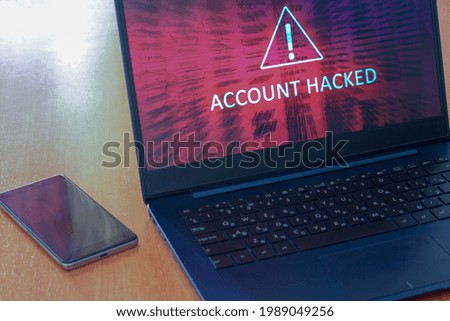 Hacked account concept on laptop screen and cellphone on a table with a dark screen. Warning triangular sign with exclamation mark symbol. Red abstract background. Horizontal.