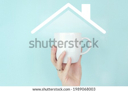 Girl hand hold morning coffee cup with sign home Icon on blue background