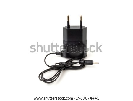 Old and outdated mobile phone charger isolated on white background.