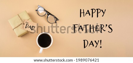 Happy Fathers Day greeting cart. Gift present boxes, eyeglasses, cup of coffee on neutral background. Top view, flat lay, banner image