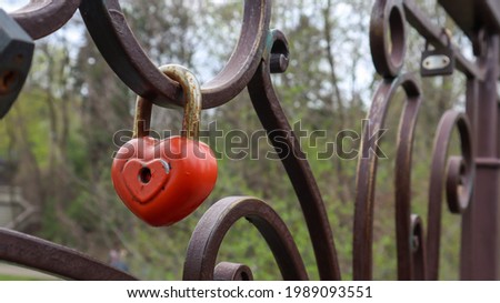 Red padlock metal love heart shaped lock on the bridge. The concept of love. Valentine's day background