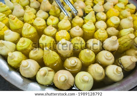 Boiled corn arranged in a basin for sale in the Thai market.