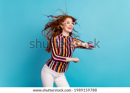 Photo of sweet red hairdo lady dance look empty space wear spectacles colorful shirt isolated on blue color background