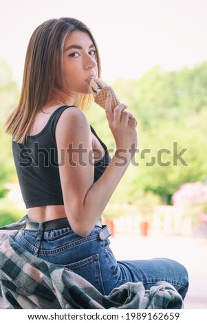 Happy girl enjoys ice cream outdoors. Portrait